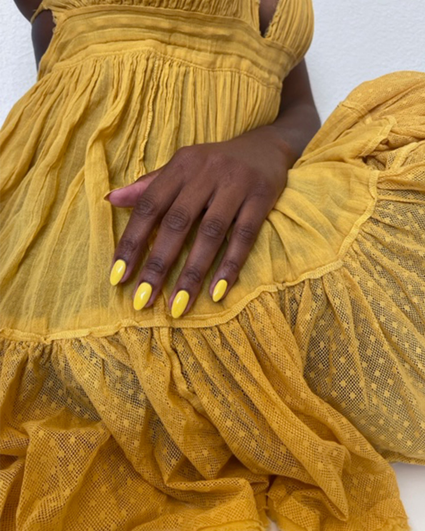 photo of hands with yellow pure polish and yellow dress